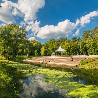 Zdjęcie przedstawia Park Centralny w Olsztynie poprzez który płynie rzeka Łyna.
