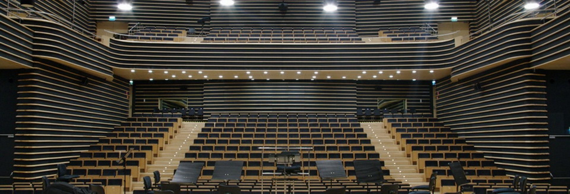 Zdjęcie przedstawia scenę oraz widownię w Filharmonii Warmińskiej w Olsztynie. 