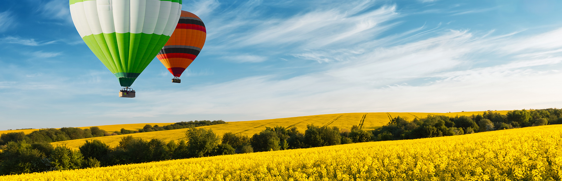 Dwa balony podczas lotu nad mazurskimi polami. 