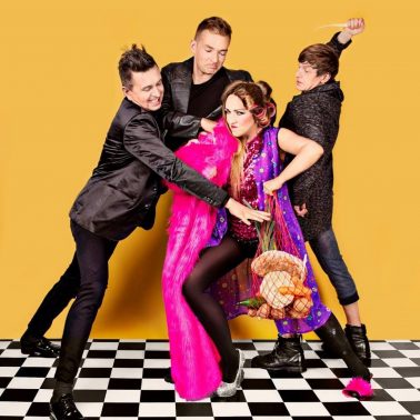Zdjęcie zapraszające 26 marca do Giżycka na Kabaret Jurki "Last minute". Na zdjęciu wykonawcy kabaretu Jurki podczas odgrywania sceny kabaretowej.