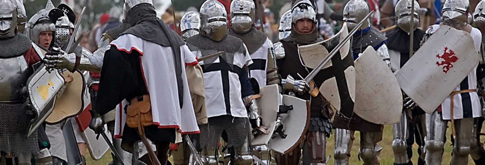 Zdjęcie zapraszające do Grunwaldu na 13 edycję Inscenizacji Bitwy pod Grunwaldem 2020. Na zdjęciu widzimy rycerzy ubranych w zbroje i stroje krzyżaków na polu bitwy pod Grunwaldem. 