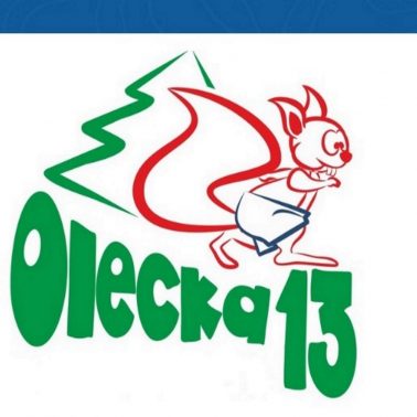 Plakat zapraszający do Olecka na 8. edycję Oleckiej Trzynastki. Grafika przedstawia napis Olecka trzynastka oraz graficzny rysunek wiewiórki.