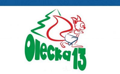 Plakat zapraszający do Olecka na 8. edycję Oleckiej Trzynastki. Grafika przedstawia napis Olecka trzynastka oraz graficzny rysunek wiewiórki.