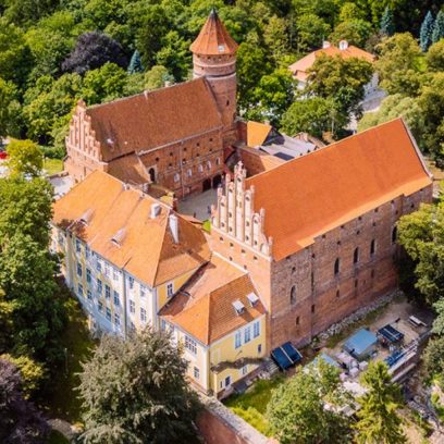 Zamek w Olsztynie z lotu ptaka. Zamek zlokalizowany w centrum obok Starego Miasta w Olsztynie otoczony drzewami.  