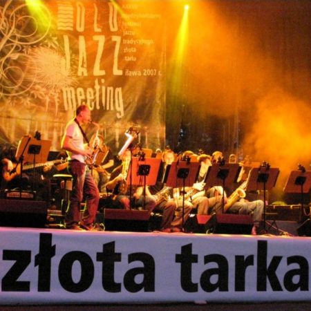 Plakat zapraszający na Międzynarodowy Festiwal Jazzu Tradycyjnego OLD Jazz Meeting "Złota Tarka" w Iławie.  