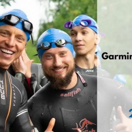Zdjęcie zapraszające do Gołdapi na cykliczną imprezę Garmin Iron Triathlon Gołdap 2021. Na zdjęciu widzimy zadowolonych zawodników przed rozpoczęciem zawodów. 