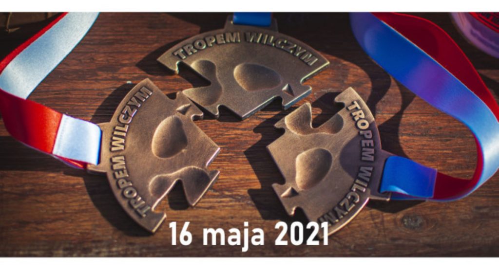 Zdjęcie zapraszające do Ełku na 9. edycję Biegu Pamięci Żołnierzy Wyklętych "Tropem Wilczym" – Ełk 2021. Na zdjęciu medal z zawodów.