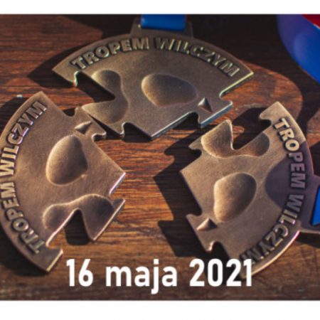Zdjęcie zapraszające do Ełku na 9. edycję Biegu Pamięci Żołnierzy Wyklętych "Tropem Wilczym" – Ełk 2021. Na zdjęciu medal z zawodów.