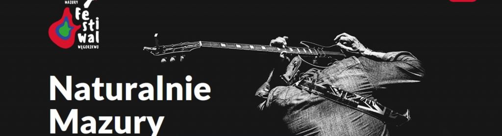 Zdjęcie zapraszające do Węgorzewa na Festiwal Naturalnie Mazury - Węgorzewo 2021. Na zdjęciu artysta grający na gitarze.  