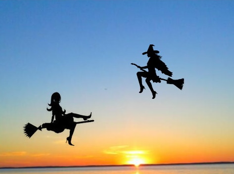 Plakat graficzny zapraszający do Fromborka na 6. edycję Fromborskiego Zlotu Czarownic - Frombork 2021. Na zdjęciu widzimy panoramę zachodzącego słońca, a na niebie dwie postacie czarownic latających na miotle.  