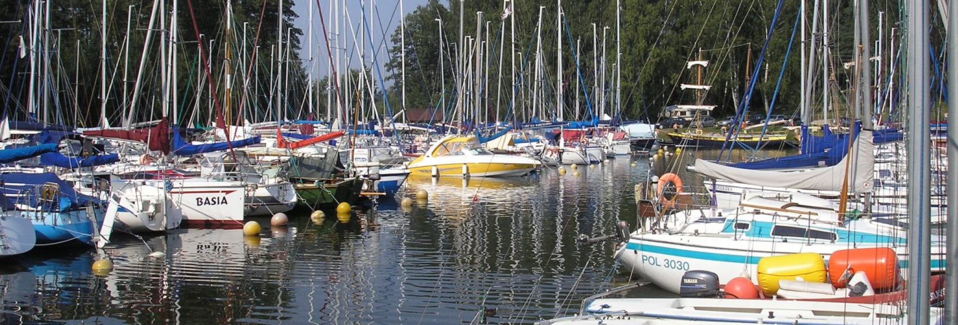 Ekologiczna przystań żeglarska Korektywa w Piaskach. Na zdjęciu zacumowane jachty w porcie.