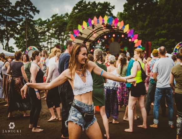 Zdjęcie z Festiwalu Wibracje, który promuje dbanie o siebie, ekologię, zrównoważony rozwój, życie w harmonii i zdrowiu ze sobą i otaczającym światem. Na zdjęciu kobieta tańcząca podczas koncertu. 