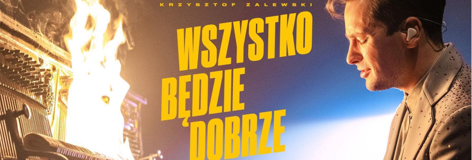 Zdjęcie zapraszające do Mrągowa na koncert Krzysztofa Zalewskiego "Wszystko będzie dobrze" - Mrągowo 2021. Na zdjęciu postać artysty podczas gry na fortepianie, który płonie. 