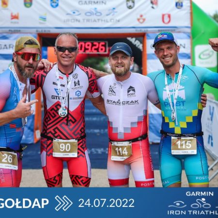 Plakat graficzny zapraszający do Gołdapi na cykliczną imprezę Garmin Iron Triathlon Gołdap 2022.