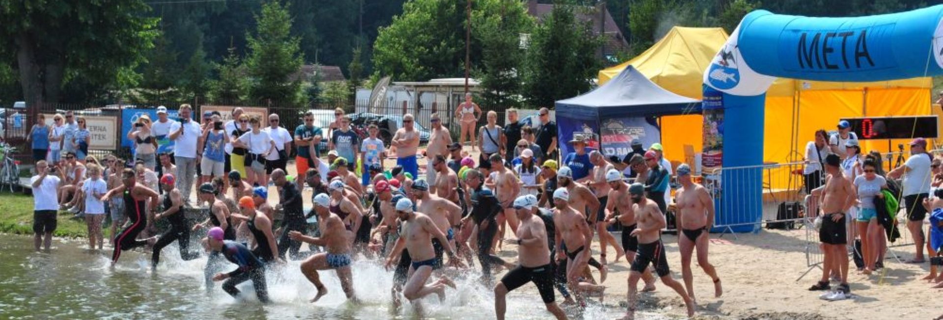 Plakat graficzny - zdjęcie zapraszające do Wilkas na 18. edycję Ogólnopolskich Mistrzostwa Mazur w Pływaniu Długodystansowym Wilkasy 2022.